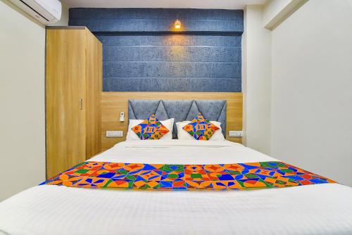 Vastral的住宿－FabExpress Canada，一间卧室配有一张大床和色彩缤纷的被子