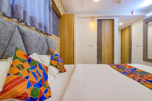 a bedroom with a white bed with colorful pillows at Hotel Canada in Vastral