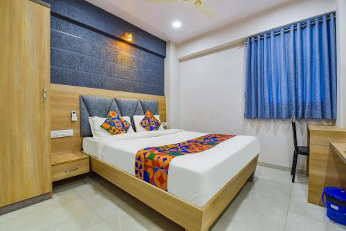 a bedroom with a large bed with a blue curtain at Hotel Canada in Vastral