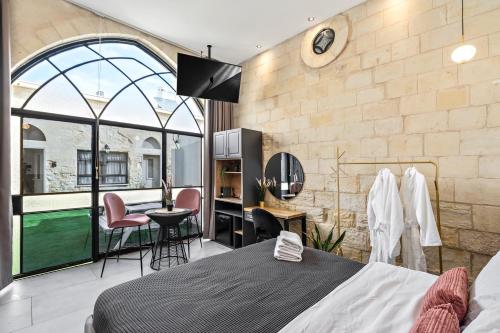 a bedroom with a bed and a large window at Old City Boutique - בוטיק העתיקה מבית רשת מלונות לה פינקה in Beer Sheva