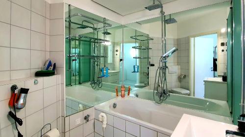a bathroom with a tub with a shower and a mirror at ✪ Beautiful Studio in Center with Amazing View ✪ in Mannheim