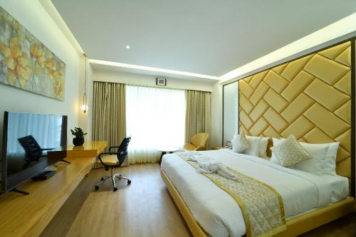 a hotel room with a large bed and a desk at The President Hotel, kumarapark in Bengaluru