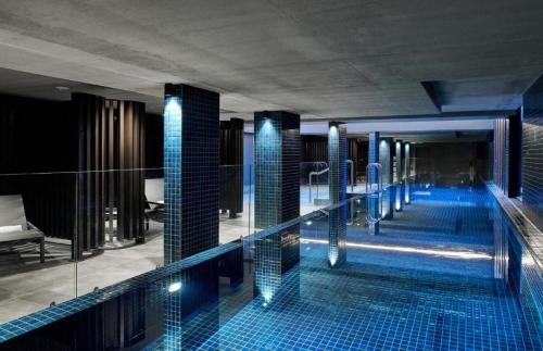 una piscina en un hotel con azulejos azules en 2 Bed 2 Bath Luxury Apartment in Braddon Canberra - Free heated pool, gym, parking, en Canberra