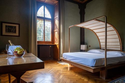 1 dormitorio con cama, mesa y ventana en Il Castello Di San Gaudenzio, en Cervesina