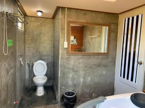 a bathroom with a toilet and a sink and a mirror at WC Coffee&ไร่หวานซึ้ง in Mae Hong Son