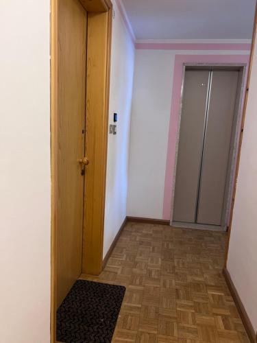 an empty room with a door and a rug at EMARGHE, CASA A MOENA in Moena