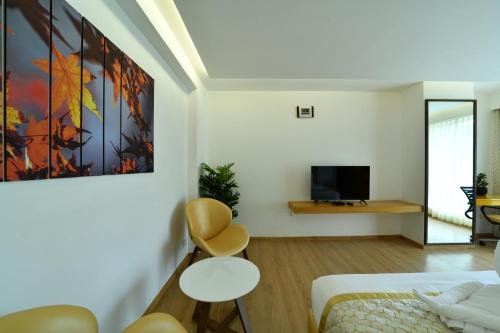 a room with a bed and a tv and a couch at The President Hotel, kumarapark in Bengaluru