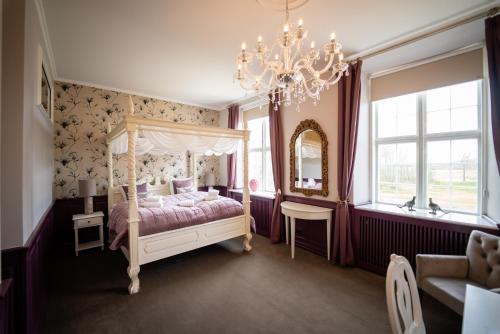 a bedroom with a canopy bed and a chandelier at Kragerup Gods in Ruds-Vedby