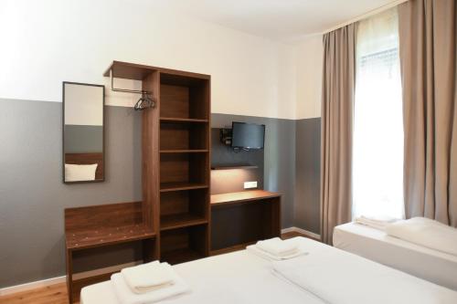 Habitación de hotel con cama y espejo en Hotel Apadana Frankfurt en Frankfurt