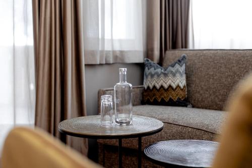 two tables with glasses on top of them next to a couch at Hotel Welponer in Selva di Val Gardena