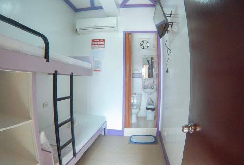 um pequeno quarto com um beliche e uma casa de banho em RedDoorz @ Isabelle Tourist Hotel Hinatuan em Hinatuan