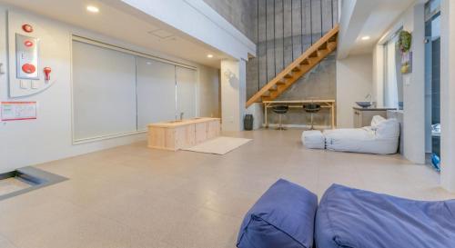 a living room with a couch and a staircase at Hinokki Haesuzzim Resort in Geoje 