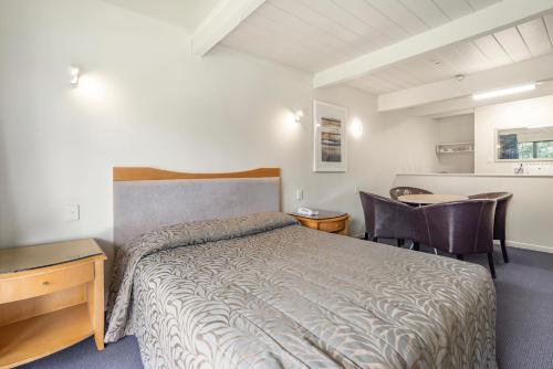 a bedroom with a bed and a table and chairs at Capital Lodge Motor Inn in Wellington