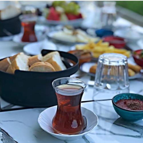 a table topped with plates of food and a cup of tea at Eleia Hotel İznik in Bursa