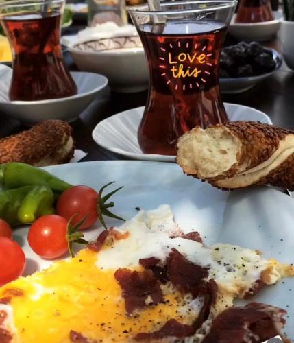 a table topped with plates of food with eggs and bread at Eleia Hotel İznik in Bursa