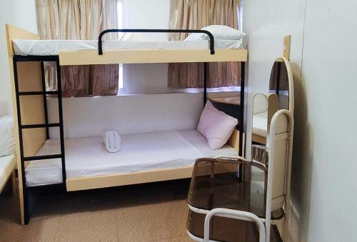 a room with two bunk beds with a window at RedDoorz @ Isabelle Tourist Hotel Hinatuan in Hinatuan