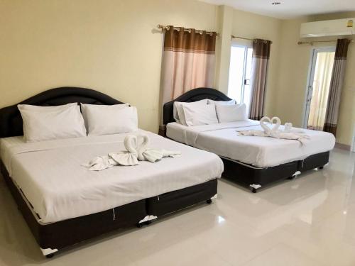 zwei Betten in einem Zimmer mit weißen Handtüchern in der Unterkunft Seksiri in Udon Thani