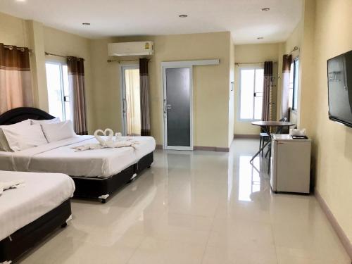 a hotel room with two beds and a television at Seksiri in Udon Thani