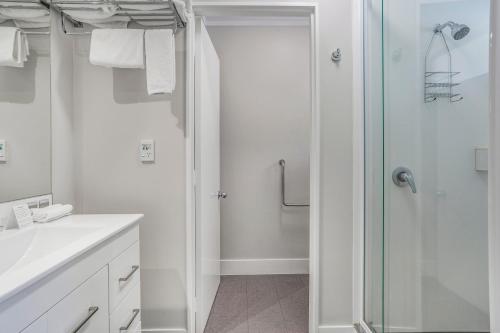 a white bathroom with a shower and a sink at Capital Lodge Motor Inn in Wellington