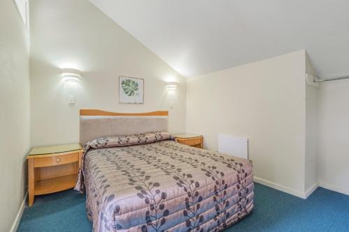 a hotel room with a bed and a nightstand and a bed sidx sidx sidx at Capital Lodge Motor Inn in Wellington