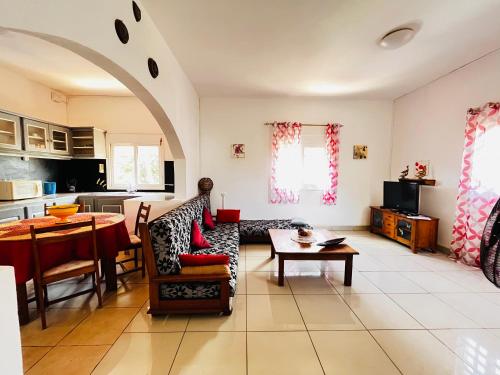 ein Wohnzimmer mit einem Sofa und einem Tisch in der Unterkunft Régina Lodge Diégo Suarez Madagascar in Diego Suarez