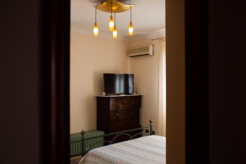 een slaapkamer met een bed en een tv op een dressoir bij Mare Nostrum Casa Vacanza in Licata