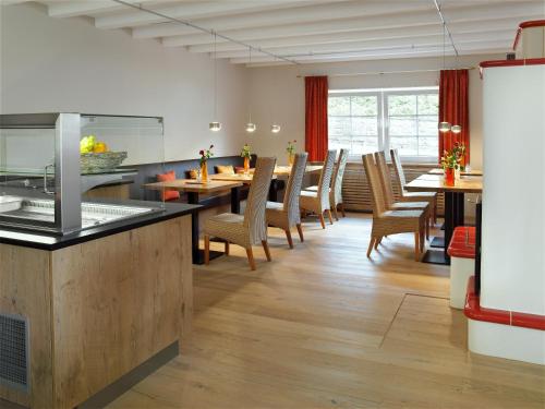 a kitchen and dining room with tables and chairs at Merker's Hotel & Restaurant Bostalsee in Bosen-Eckelhausen