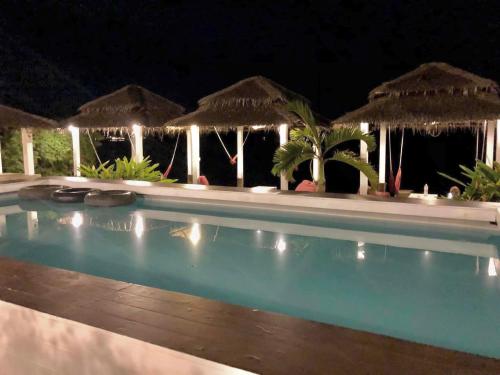 a swimming pool at night with umbrellas at Paradise Cottage in Ko Chang