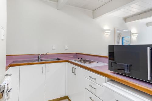 a kitchen with a sink and a microwave at Capital Lodge Motor Inn in Wellington