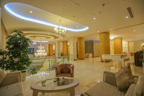 a lobby with a table and a piano at Gabala Garden Hotel in Gabala