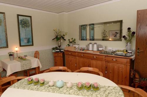 une salle à manger avec une table et une cuisine dans l'établissement Pension Biewer, à Ockfen