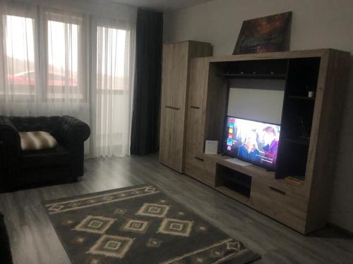 a living room with a television in a wooden entertainment center at Ilinca-ZGATIA in Piatra Neamţ