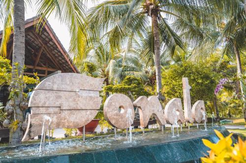 a sign in front of a resort with palm trees at Sonata Resort & Spa in Phan Thiet