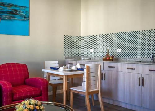 a living room with a table and a red chair at Haile Grand Addis Ababa in Addis Ababa