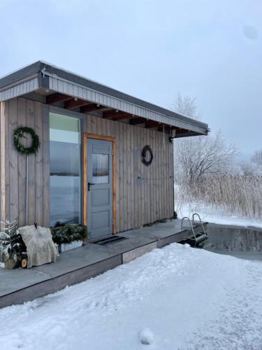 una pequeña casa con un porche en la nieve en Dzintarkrasts, en Jūrmala