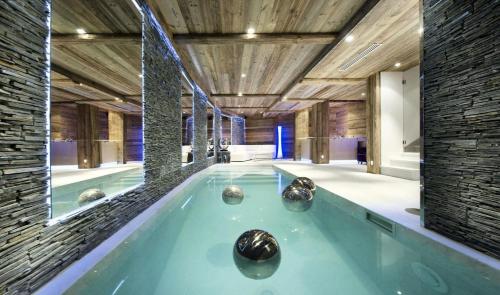 a jacuzzi tub in a room with rocks in it at Résidence Eden - Chalets pour 10 Personnes 754 in Courchevel