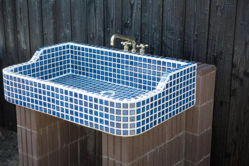 a blue tiled sink on a wooden fence at Jikukan Mukae in Taisha