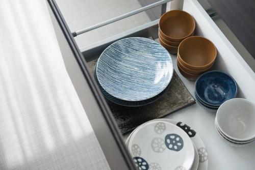 a drawer filled with blue and white plates and bowls at Jikukan Mukae in Taisha