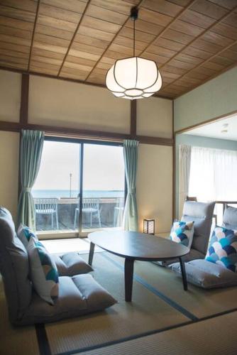 a living room with a table and a couch at Jikukan Mukae in Taisha