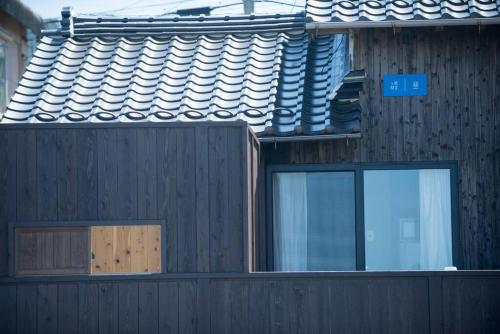a building with two windows and a roof at Jikukan Mukae in Taisha