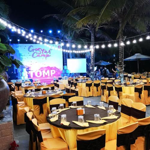 a large banquet hall with tables and chairs and a screen at Sonata Resort & Spa in Phan Thiet