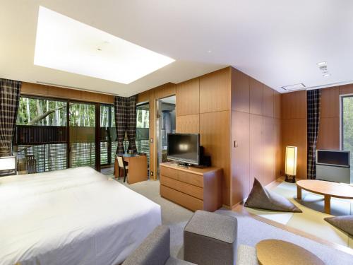 a bedroom with a bed and a flat screen tv at Fufu Atami in Atami