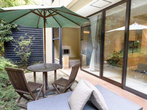 a patio with a table and chairs and an umbrella at Fufu Atami in Atami