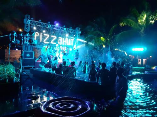 a group of people standing in the water at night at Sonata Resort & Spa in Phan Thiet