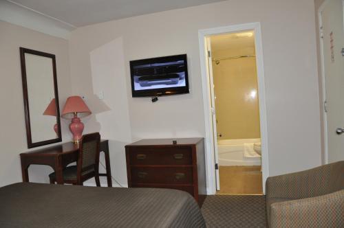 a bedroom with a bed and a bathroom with a tub at Royal Inn in Burlington