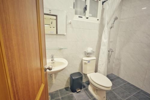 小琉球にある寮寓x綺澄の白いトイレと洗面台のあるバスルーム