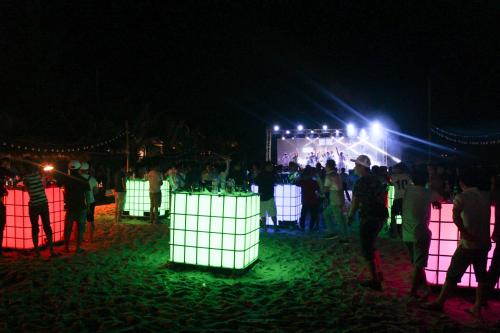 a group of people standing around a stage at night at Sonata Resort & Spa in Phan Thiet