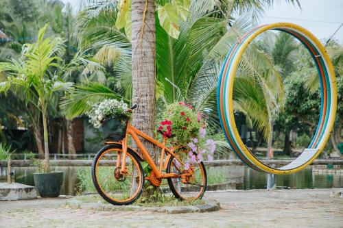 an orange bike with flowers and a large mirror at Sonata Resort & Spa in Phan Thiet