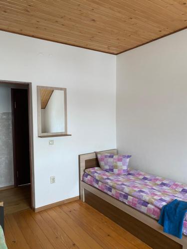 een slaapkamer met een bed en een houten plafond bij Домашній Затишок in Stryi