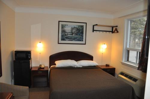 1 dormitorio con 1 cama con 2 mesitas de noche y 2 lámparas en Royal Inn en Burlington